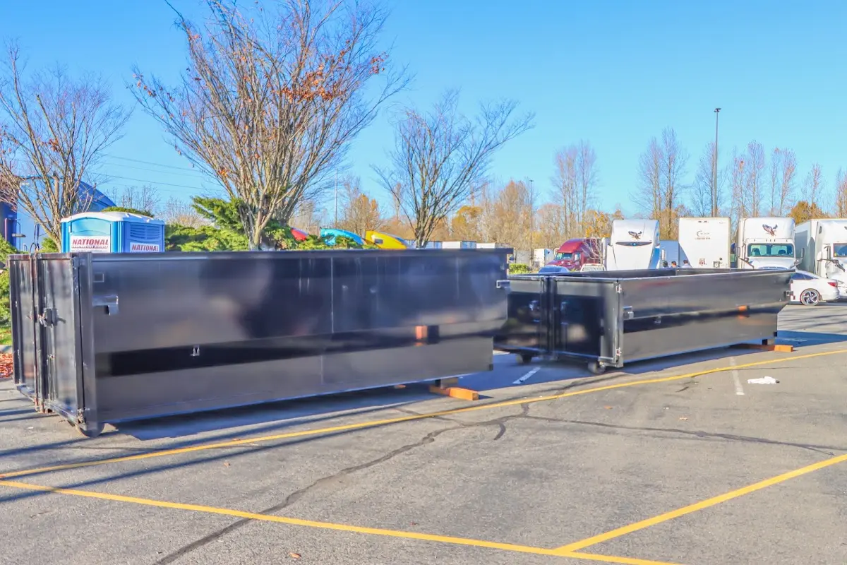 Professional dumpster rental service with roll-off container on residential driveway in Eastmont